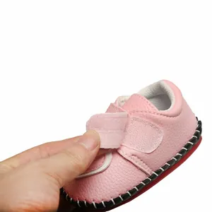 Gros plan d'une chaussure de marche rose pour bébé avec bande velcro ajustable