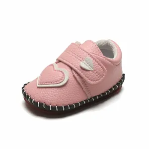 Vue détaillée d'une chaussure de bébé rose avec motif cœur et semelle surpiquée