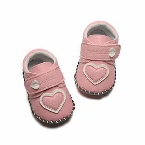 Vue détaillée de chaussures de marche pour bébé roses avec motif cœur appliqué