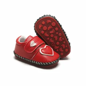 Détail de chaussures de marche rouges pour bébé avec cœur et semelle en caoutchouc