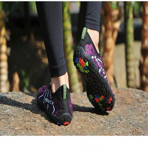 Primo piano di scarpe da scoglio viola antiscivolo indossate su una roccia all'aperto