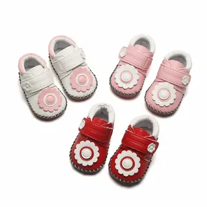 Vue de dessus montrant divers chaussons souples pour bébé avec des détails floraux