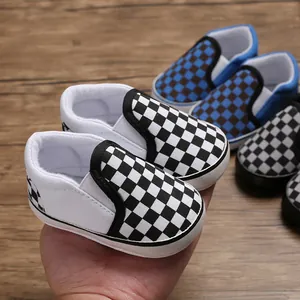 Detailed macro view of checkered soft sole canvas baby walker shoes for infants