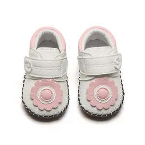 Vue détaillée de chaussures de marche blanches pour bébé avec décors fleurs roses