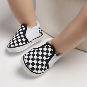 Close-up of black and white checkerboard baby walker shoes with soft slip-on soles