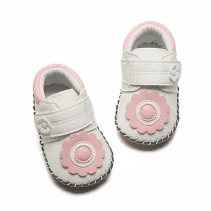 Vue de dessus détaillée de chaussures de marche souples pour bébé blanches avec fleurs roses