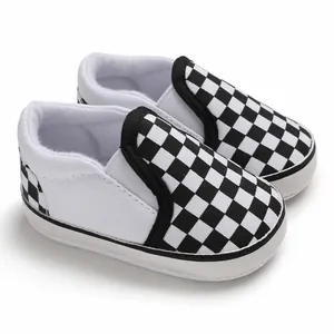 Close-up view of black and white checkered slip-on soft-sole baby walker shoes for infants