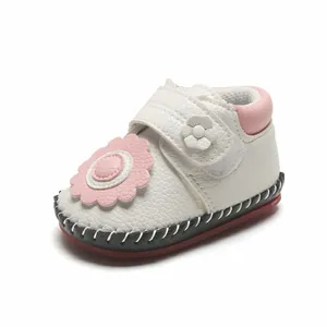 Détail de chaussures de marche pour bébé blanches avec fleur rose et semelle souple