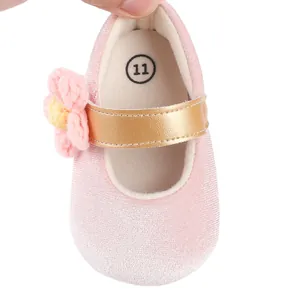 Dettaglio scarpa neonata in velluto rosa con fiore in maglia e cinturino dorato