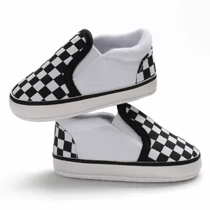 Detailed macro view of checkered slip-on baby walker shoes with soft white soles