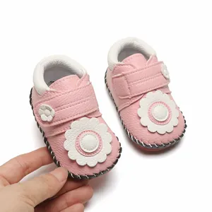 Gros plan de chaussures souples rose pour bébé avec détails de fleurs blanches élégantes