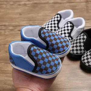 Close-up view of blue and brown checkered baby slip-on walker shoes with soft rubber soles