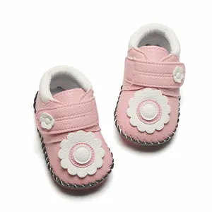 Chaussures bébé roses avec décoration de fleurs blanches et semelle en caoutchouc souple