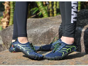 Primo piano di scarpe da wading antiscivolo a cinque dita per coppie in ambiente roccioso.