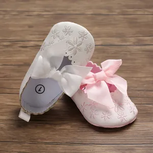 Detailansicht der Baby-Prinzessinnenschuhe mit Schleifen und Blumenstickerei auf weicher Sohle