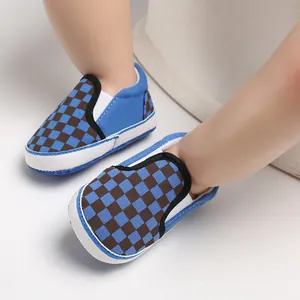 Close-up view of blue and brown checkered slip-on baby walker shoes with soft white soles.