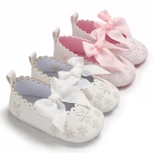 Detailansicht von Baby-Prinzessin-Schuhen mit rosa-weißen Stickereien und Schleifen