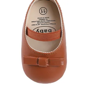 Gros plan sur chaussure bébé marron avec nœud et bride élastique