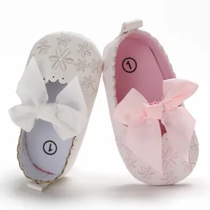 Detailansicht von rosa und weißen Babyschuhen mit Schleifen und Blumenstickereien