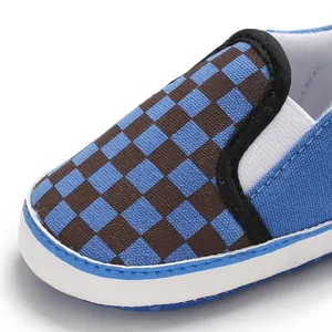 Macro view of blue and brown checkered canvas infant slip-on walker shoe with soft sole