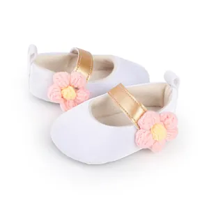 Detail of white baby girl princess walker shoes with pink crochet flower decoration
