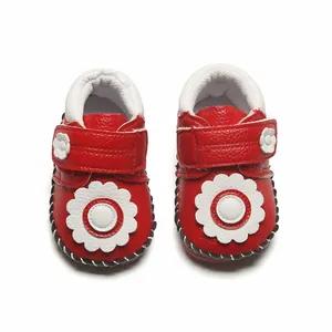 Vue détaillée de dessus de chaussures de marche rouges pour bébé avec décor de fleurs