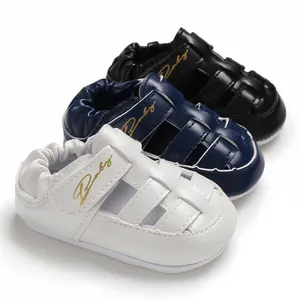 Detail view of baby summer sandals in white, navy blue, and black with velcro strap