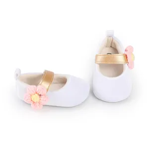 Soft white fabric baby walking shoes featuring golden strap and pink knitted flower accent