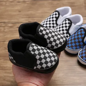 Detail view of black and white checkerboard baby walker shoes with flexible soft soles