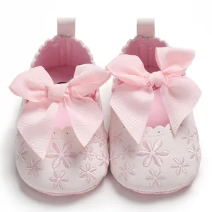 Detailansicht rosa Baby-Prinzessin-Schuhe mit großer Schleife und Blumenstickerei