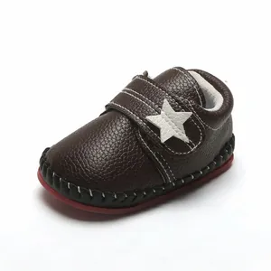Gros plan sur une chaussure de marche bébé marron avec étoile blanche et semelle souple