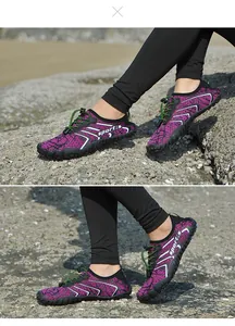Dettaglio ravvicinato delle scarpe da scoglio viola a cinque dita su terreno roccioso