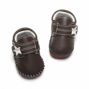 Détail de chaussures de marche pour bébé marron foncé avec étoile et semelle souple.