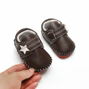 Détail de chaussures de marche pour bébé marron à semelle souple avec étoile et scratch