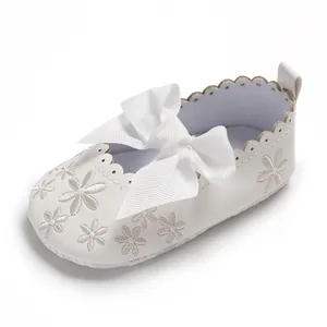 Nahaufnahme von weißem Baby-Prinzessin-Schuh mit großer Schleife und Stickerei