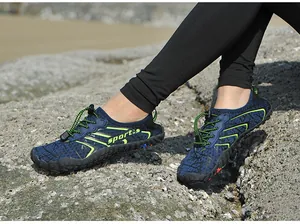 Scarpe da acqua blu antiscivolo e traspiranti su terreno roccioso della spiaggia