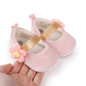Close-up detail of pink soft baby pre-walker shoes featuring a crochet flower and gold strap