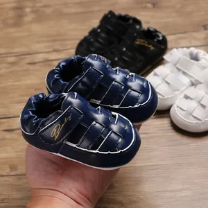 Detailed view of navy blue baby closed-toe sandals with gold Baby logo