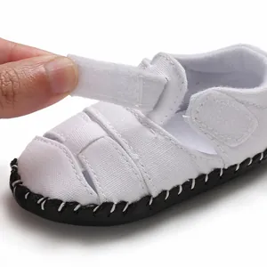 Dettaglio del sandalo in tela per neonati con chiusura a velcro regolabile.