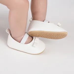 Détail de chaussures de marche blanches pour bébé fille avec nœud et semelle en caoutchouc