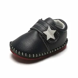 Détail de la chaussure de marche pour bébé bleu marine avec étoile et semelle rouge.