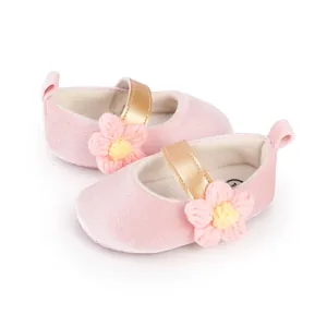 Detailed view of soft pink velvet baby walking shoes with gold strap and knit flower