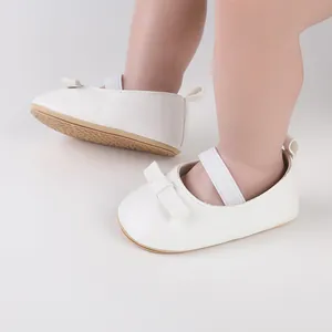 Vue latérale de chaussures de cérémonie blanches pour bébé avec nœud