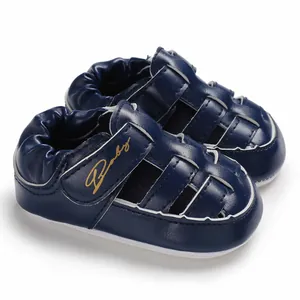 Detail view of navy blue baby sandals with anti-slip rubber sole and Baby logo