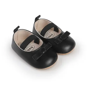 Nahaufnahme von schwarzen Lauflernschuhen für Mädchen mit Schleife und Gummiband.