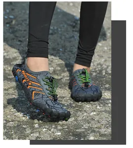 Dettaglio delle scarpe acquatiche antiscivolo indossate su una spiaggia rocciosa naturale