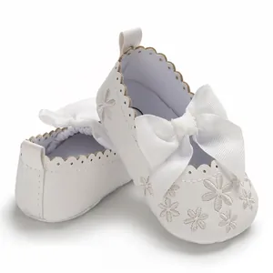 Detailansicht der weißen Babyschuhe für Mädchen mit Schleife und Blumenstickerei