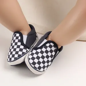 Detailed macro view of black and white checkerboard pattern soft sole baby walking shoes