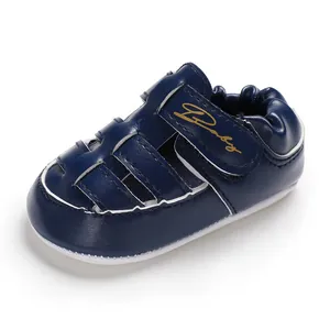 Close-up of navy blue baby sandals with non-slip rubber sole and velcro strap.