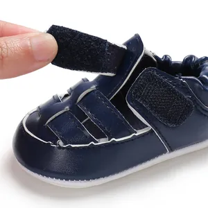 Close-up of navy blue infant sandal showing adjustable hook-and-loop strap detail